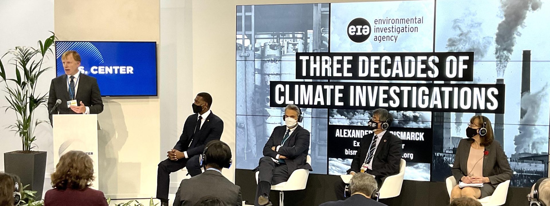 Alexander von Bismarck speaks at a panel event near a sign noting that EIA has three decades of experience in climate investigations