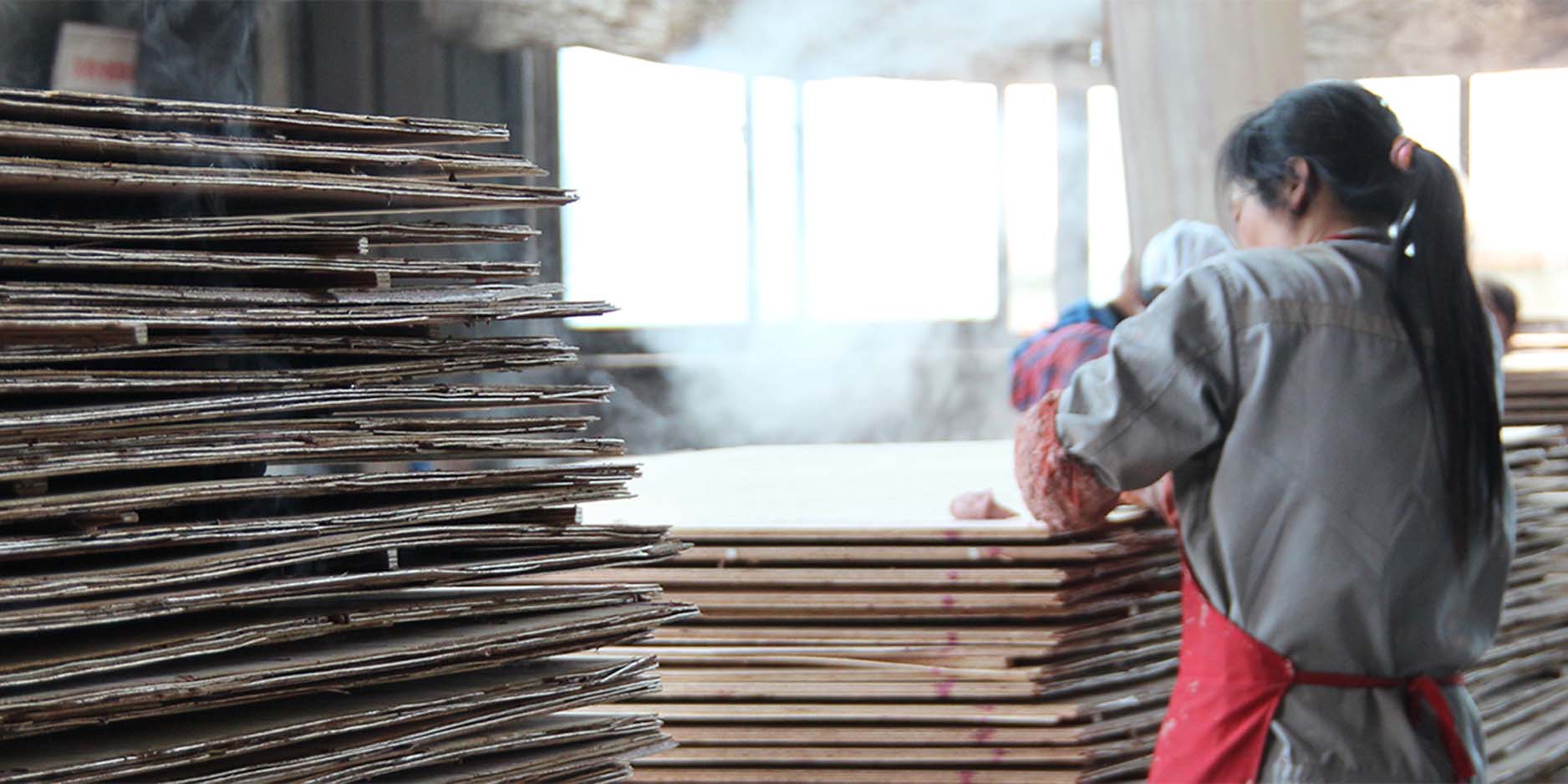 Workers surrounded by piles of plywood