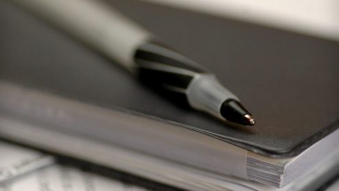 Pen resting on top of a checkbook