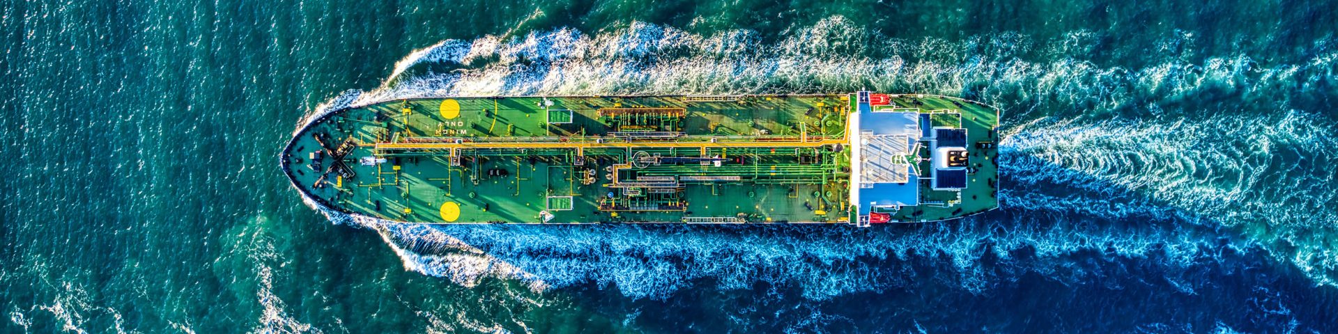 An aerial view of a cargo ship cutting through the water
