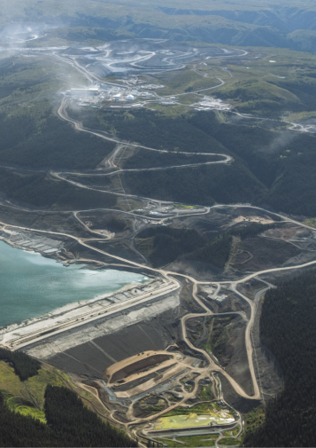Mines, roads, and a dam mar a landscape