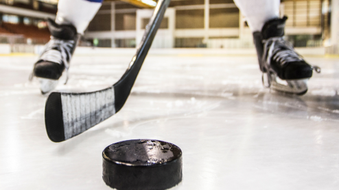 A hockey player prepares to hit a puck