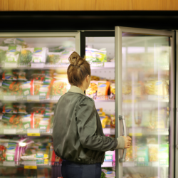 A person opens a supermarket freezer