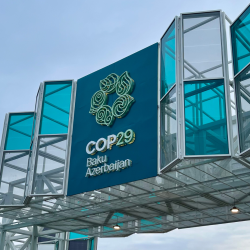 A large sign designating a glass building as COP 29 in Baku, Azerbaijan