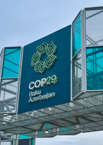 A large sign designating a glass building as COP 29 in Baku, Azerbaijan
