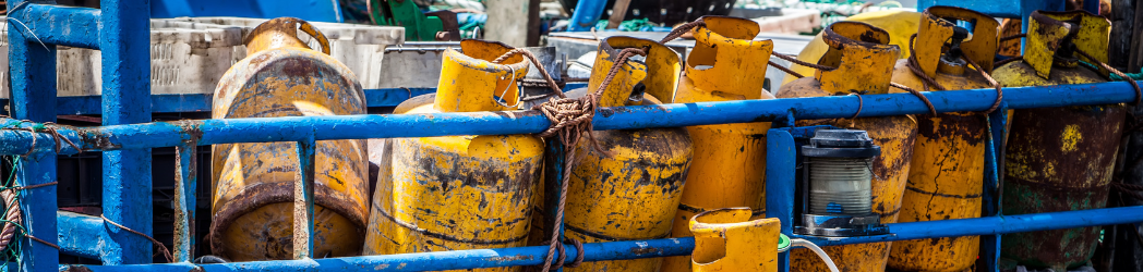 A row of rusty-looking chemical containers