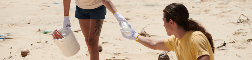 Two people exchange plastic during a beach cleanup