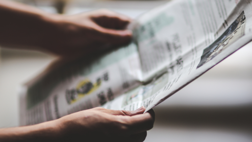 A person reads a newsletter