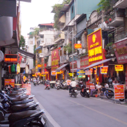Motorbikes travel down a narrow lane lined with shops