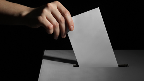 Hands submitting a piece of paper to a tip box