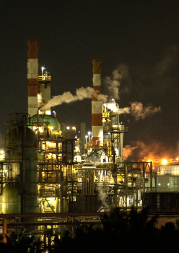 Emissions billow from a facility at night