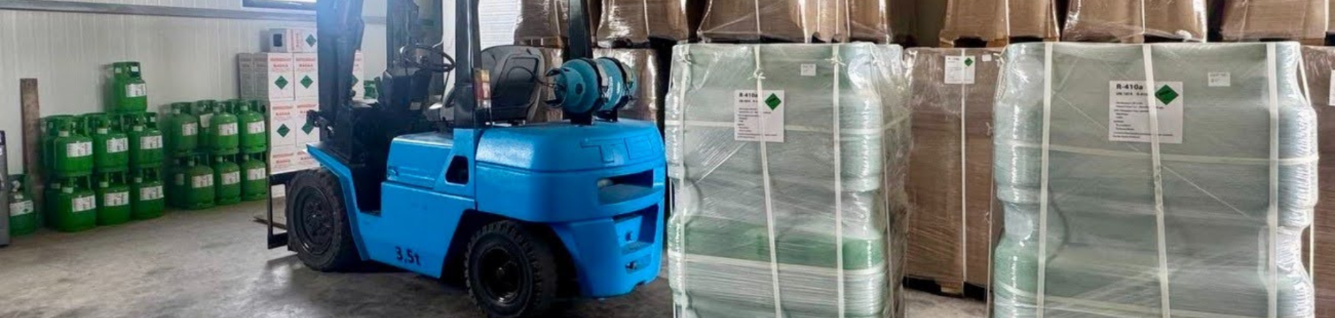 Forklift surrounded by boxes and containers of refrigerant in a warehouse