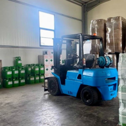 Forklift surrounded by boxes and containers of refrigerant in a warehouse
